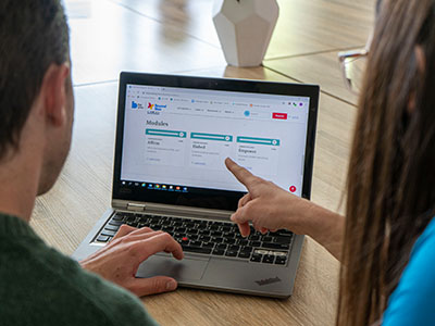 Two adults working at a laptop