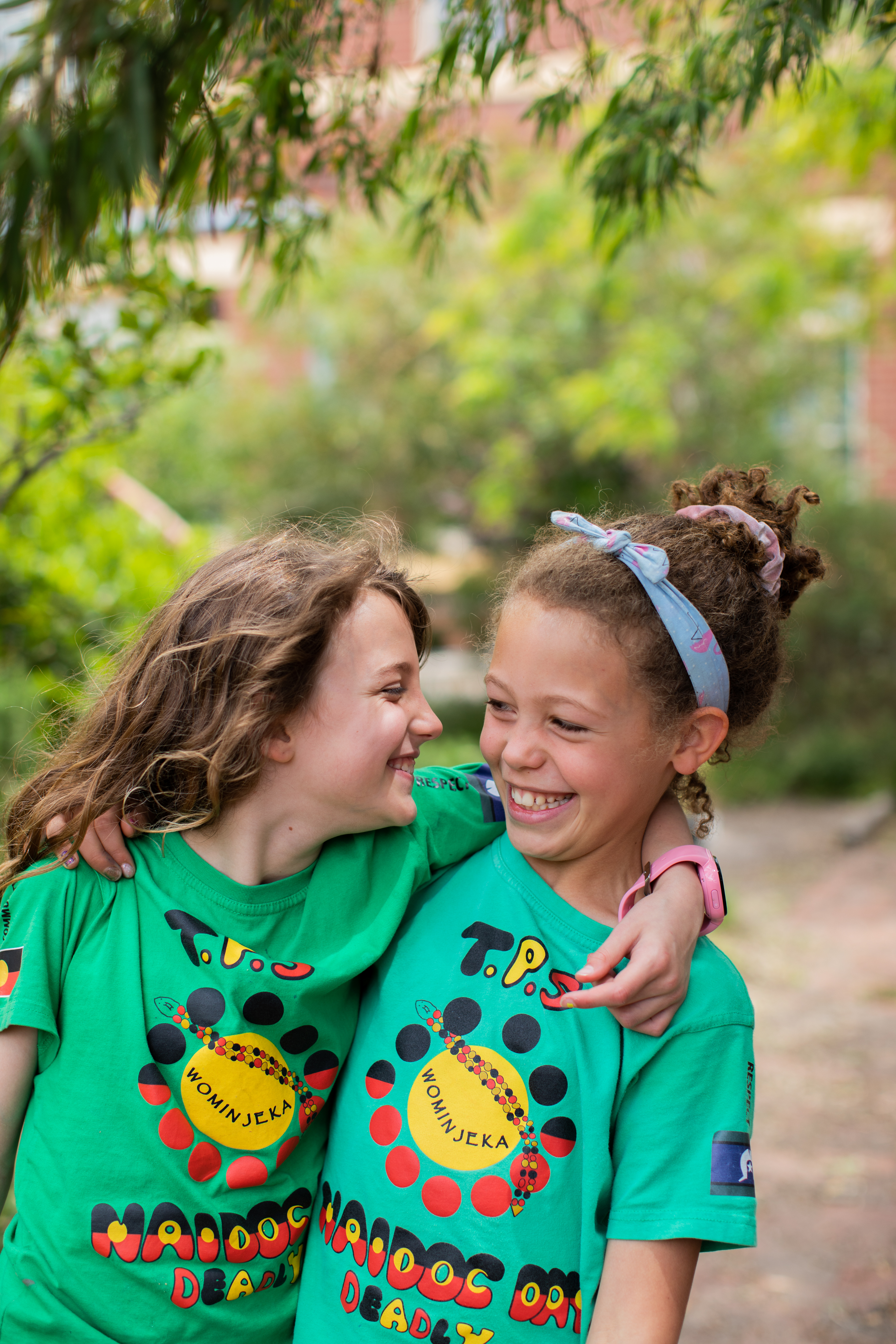 Two children smiling with their arms around each other
