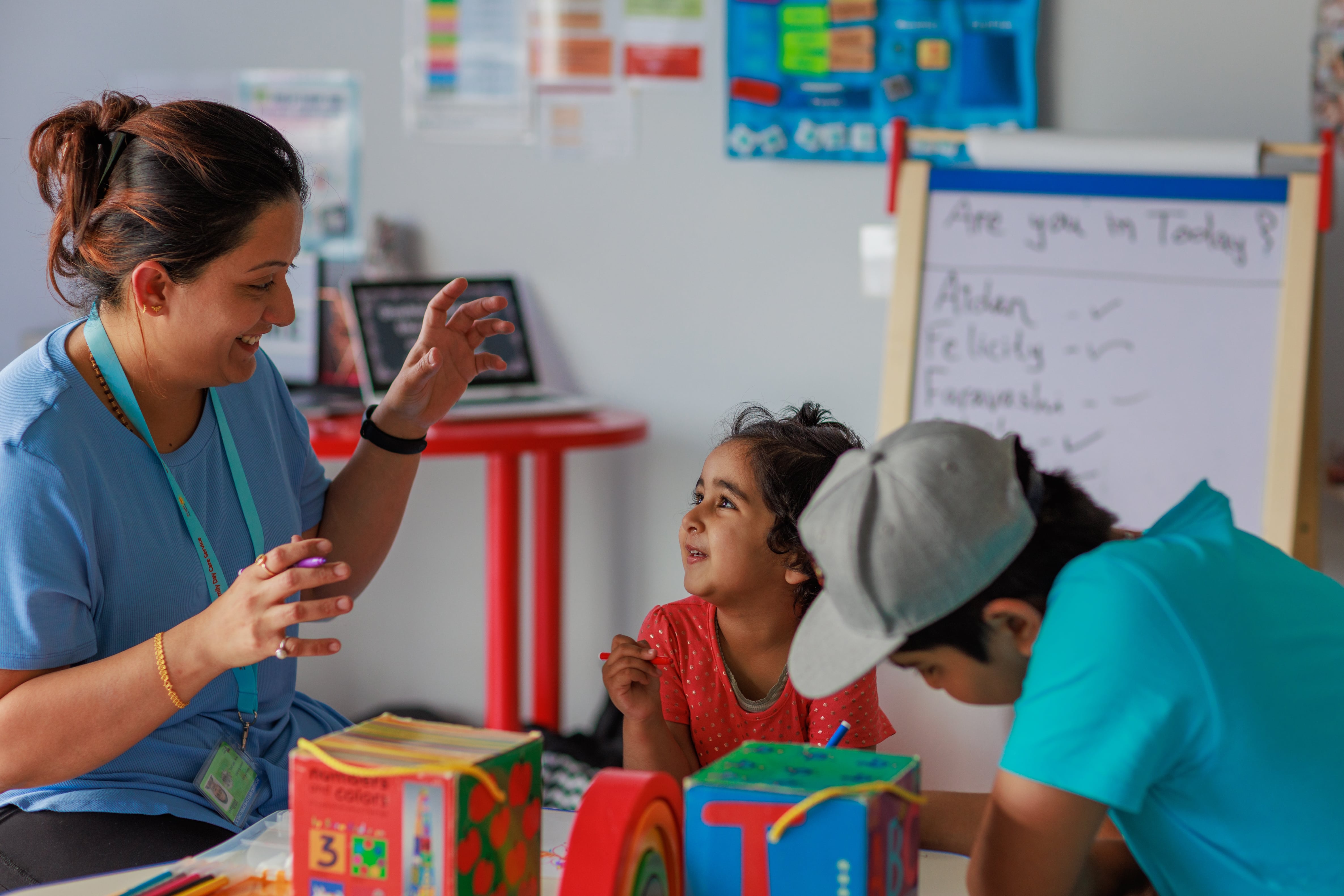 Educator teaching two young children
